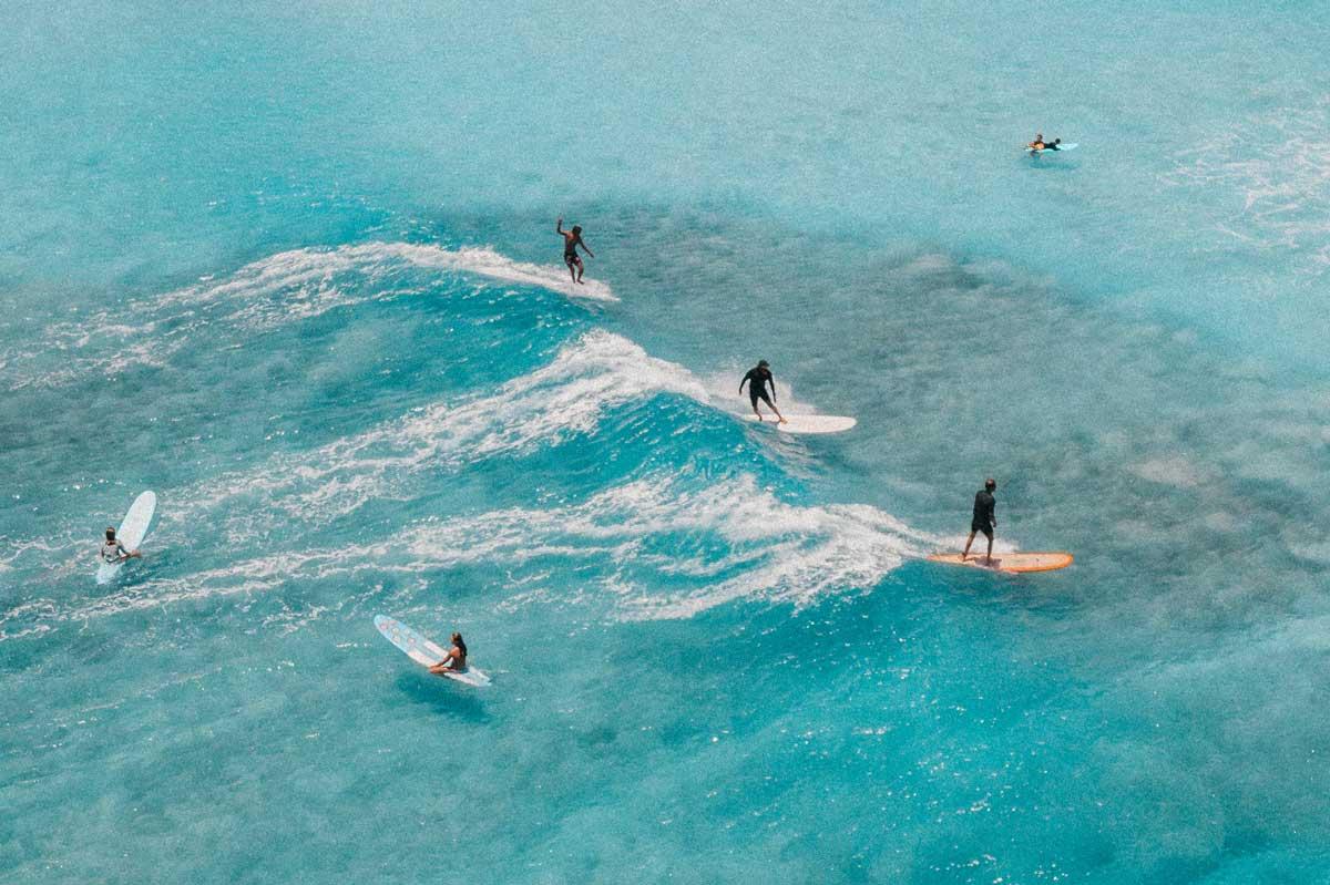 group of people surfing in oahu hawaii